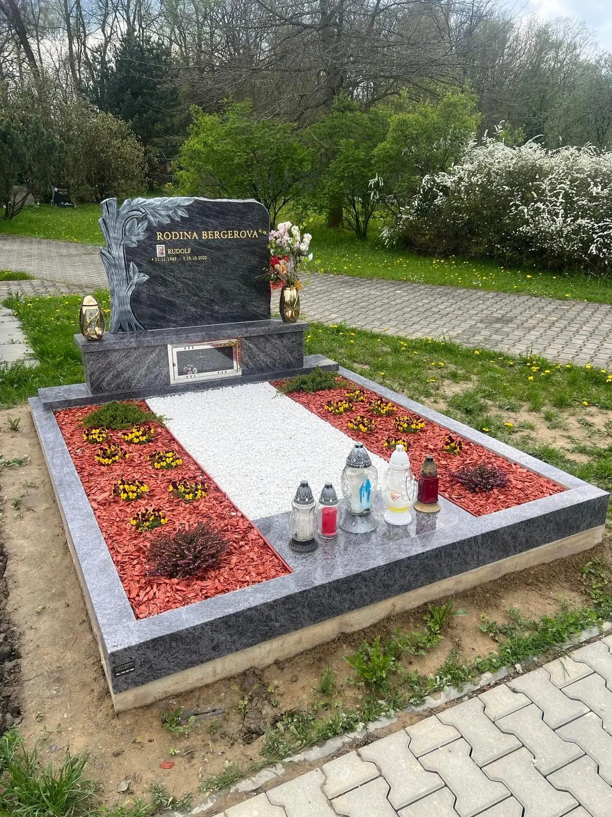 Žulový dvojhrob s ozdobnou nápisní deskou, zlatým písmem a květinovou úpravou