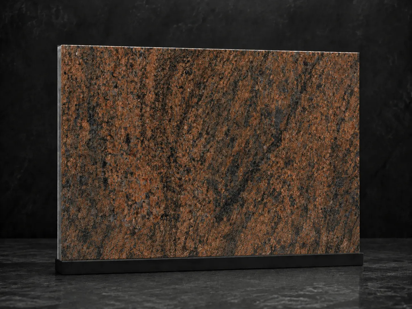 Vzorek žuly Multicolor Red s rezavě červenou barevností a nepravidelnou tmavou kresbou – kamenictví Stone Partners